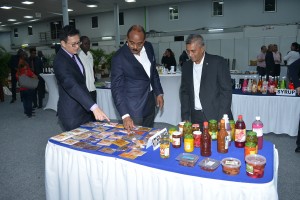 HI&T-minister Stephen Tsang, premier Gaston Browne en KKF-voorzitter Aniel Padarath bekijken enkele Surinaamse specerijen (foto: Regilio Derby)